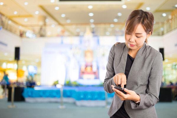 Women in shopping mall using mobile phone.
