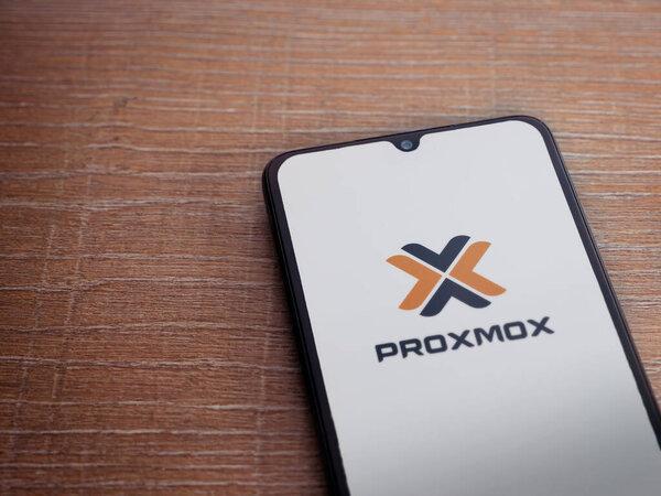 Lod, Israel - July 16 2023: Proxmox Virtual Environment app launch screen on smartphone on wooden background.带有复制空间的顶视图平面布局.