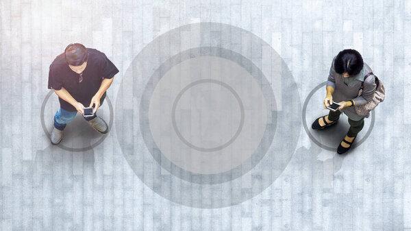 Human life in Social distance. Aerial top view with blur man with smartphone standing at pedestrian crosswalk with empty space and signage of social distancing standing.
