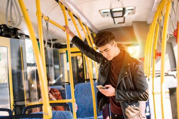 man using smartphone in bus