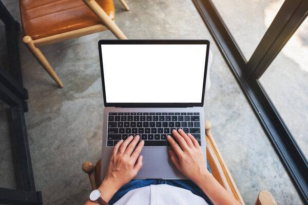 Top view mockup image of a woman using and typing on laptop computer with blank white desktop screen 