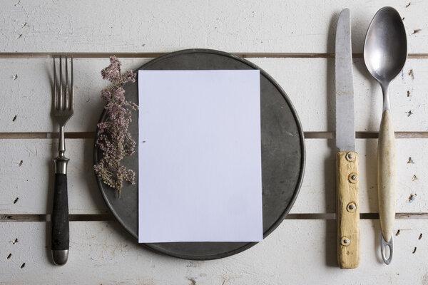 Rustic place setting menu on old white wooden