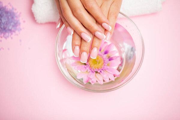 Woman hands receiving a manicure in beauty salon.