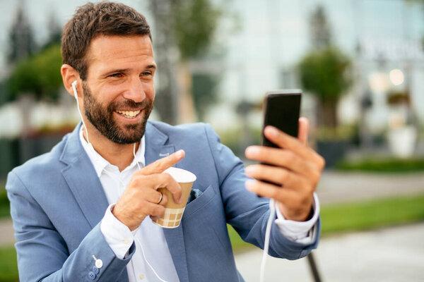 young entrepreneur in suit have video call on his smartphone at the street