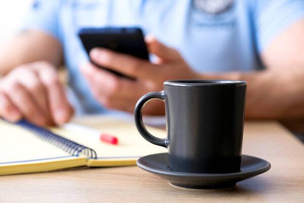 The man behind the Cup of coffee he reads a text.