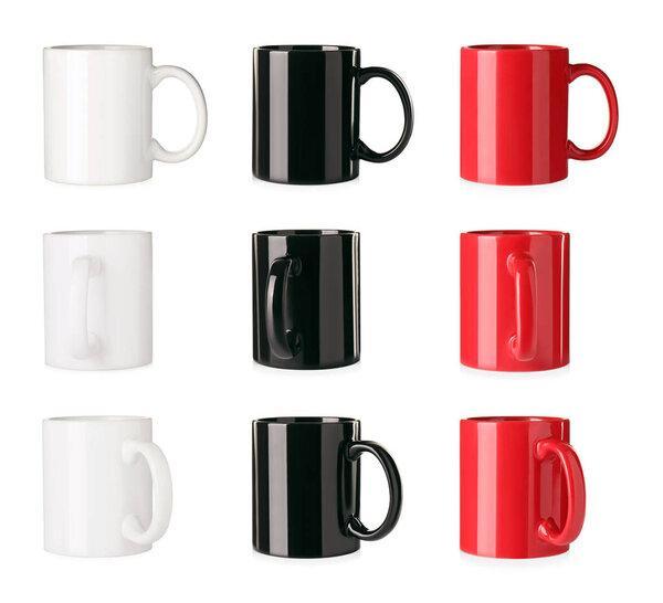 Set with different ceramic mugs on white background