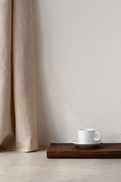 Minimalist neutral home interior, coffee cup on a wooden desk, empty white wall with copy space, beige linen curtain and stone tabletop, Scandinavian sustainable room background