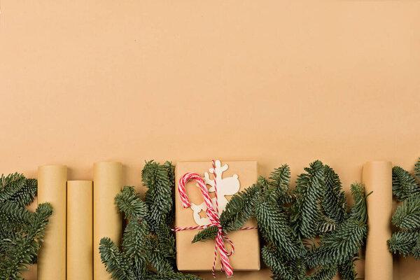 Christmas composition. gift box wrapped in craft paper, fir tree branches, candy canes. new year concept. Greeting card, xmas celebration 2022. Flat lay, top view, copy space, mockup