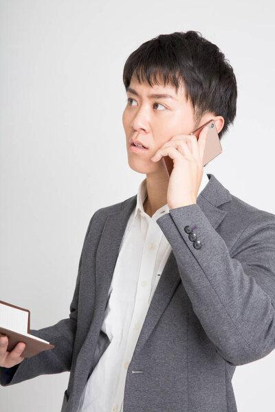 年轻的亚洲商人，手机，工作室拍摄 