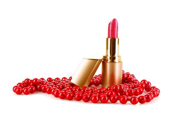 Red lipstick and beads on a white background