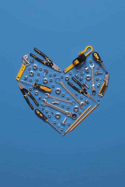 A symbolic heart made of construction tools set. Creative template for the Builder's Day, Labor Day (and similar professional holidays) or the Valentine's Day greeting card or banner. 3D render.