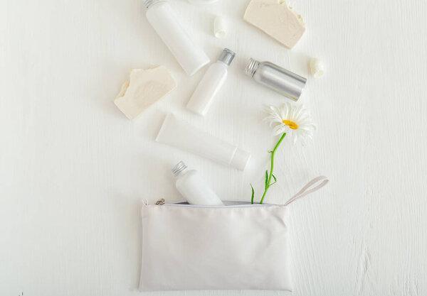 Beauty skin care hair treatment cosmetic serum oil moisturizer skin cream body butter soap lotion shampoo. Set cosmetic products in white packaging on wooden table with flowers, cosmetic bag.Flat lay.