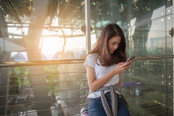 Women are using their smartphones to Flight Checking at airports.airports and technology concept