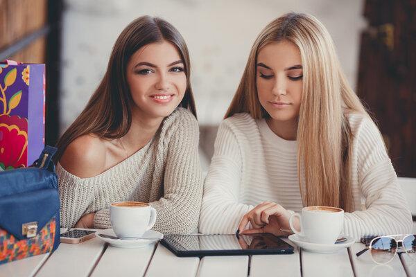Girlfriends consider photos on the digital tablet