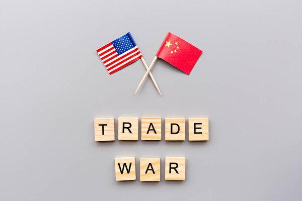 Creative top view flat lay of China and USA flags, mockup and copy space on gray background in minimal style. Concept of trade war between USA and China