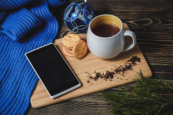 tea and smartphone in the center of cute Christmas decoration