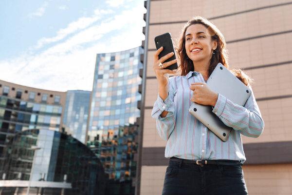 Adult business woman with mobile phone in the city