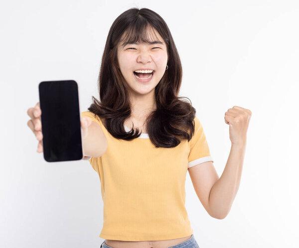 在白色背景下展示或展示手机应用和成功姿态的亚洲女孩