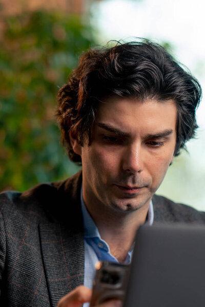 在办公室的笔记本电脑上为一个重要项目工作的一位严肃的商人金融家画像