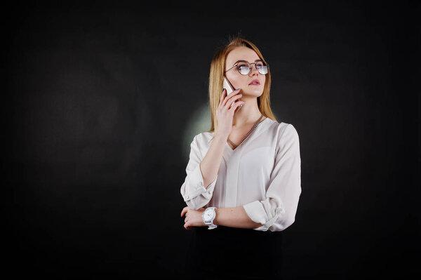 Studio portrait of blonde businesswoman in glasses, white blouse