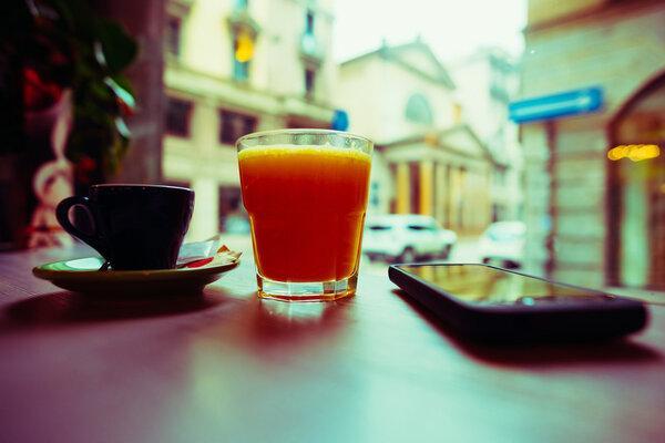 Cup of coffee, glass of juice and smartphone
