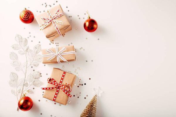 Christmas composition. Gifts, spruce branches, red decorations on a white background. Christmas, winter, new year concepts. Flat deck chair, top view, copy space.