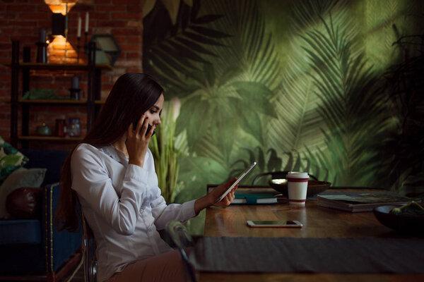 Young beautiful woman working in a stylish office in loft style