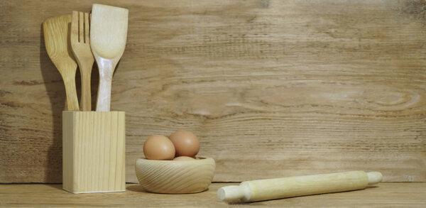 natural composition on the kitchen interior with  eggs and kitchen cutlery in wood  home decor. mock up. 