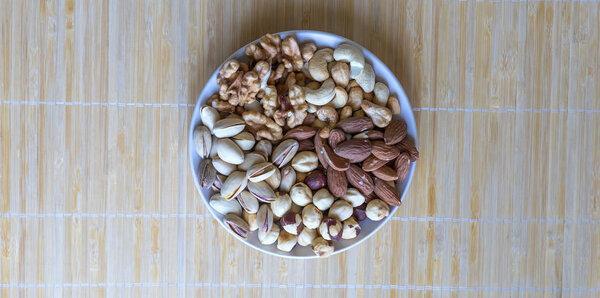 Healthy food. Nuts mix assortment on stone texture top view. Collection of different legumes for background image close up nuts, pistachios, almond, cashew nuts, peanut, walnut. image
