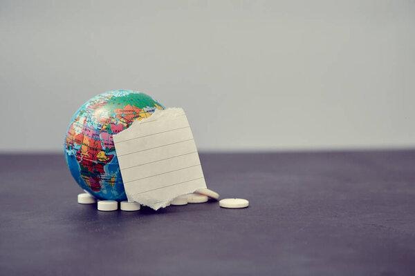 Globe with empty paper note and pills. Epidemic mockup. Novel coronavirus, COVID-19 outbreak. Global pandemic disease
