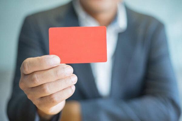 businessman holding blank business card in office, business concept
