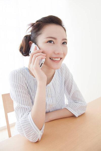 亚洲女商人在办公室里用智能手机交谈