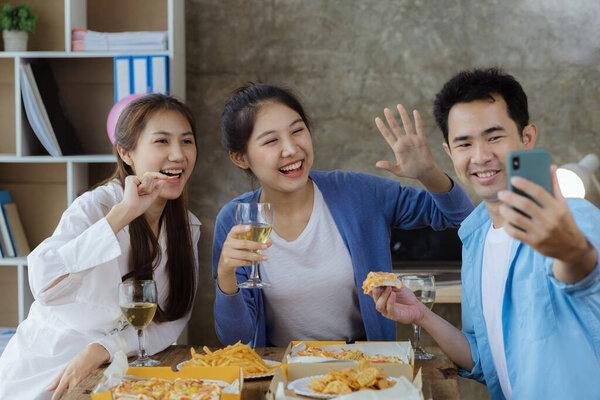 Group of young Asians having fun taking pictures at company parties, startup parties, new year parties, annual company parties, alcoholic beverages. Company employee party catering ideas, celebrations