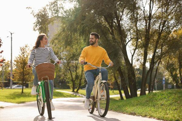 美丽的年轻夫妇骑自行车在公园，文字空间