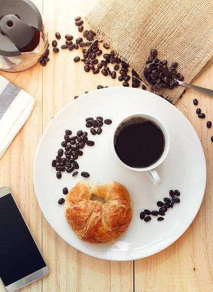Flatlay above view of a cup of hot coffee with Smart phone and C