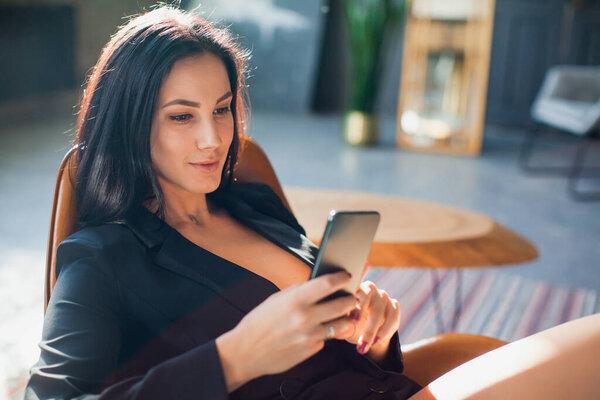Beautiful sexy blogger using smartphone at home.
