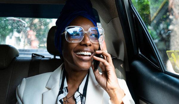 beautiful business women driving to the airport,leaving on for a working travel. Using smartphone to make a phonecall