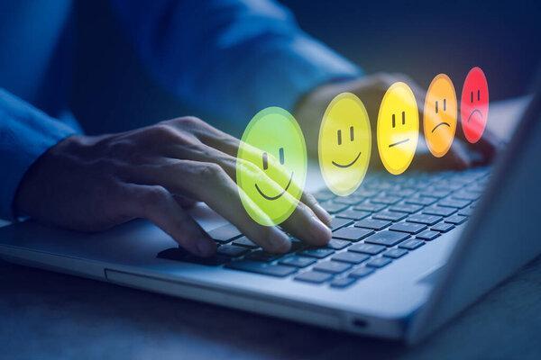 Customer reviews smiling face. Customer service evaluation and satisfaction. Businessman hands typing notebook (Laptop). Top service, ISO certification, Guarantee, Quality assurance, Standards concept.