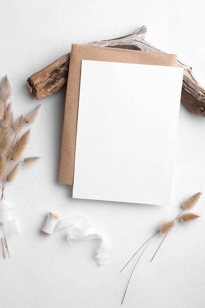 Wedding invitation card mockup 5x7 on white background with envelop and boho decor. Baby shower o bridal shower mockup. Minimal bohemian style vertical blank card mockup, thank you card, greeting card
