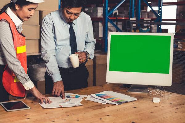 Computer with green screen display in warehouse storage room
