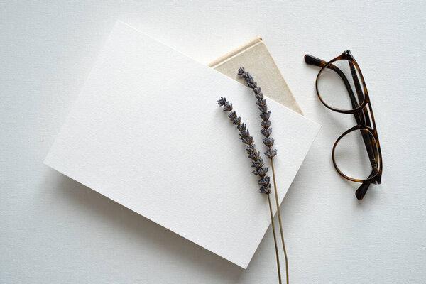 blank white invitation template, rectangle, art canvas texture, soft shadows, lavender decoration, brown glasses, white background, canvas texture, photo taken from above