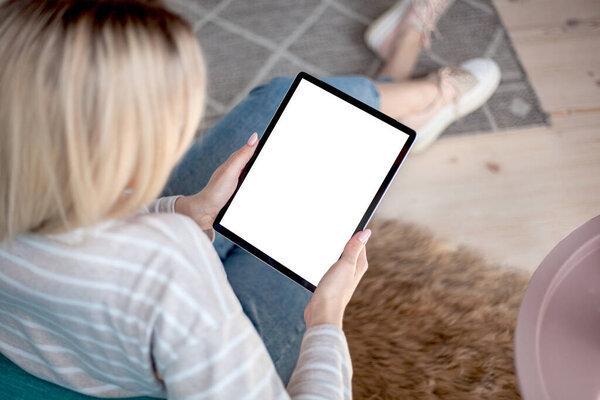 Tablet screen in the hands of young woman using a digital tablet