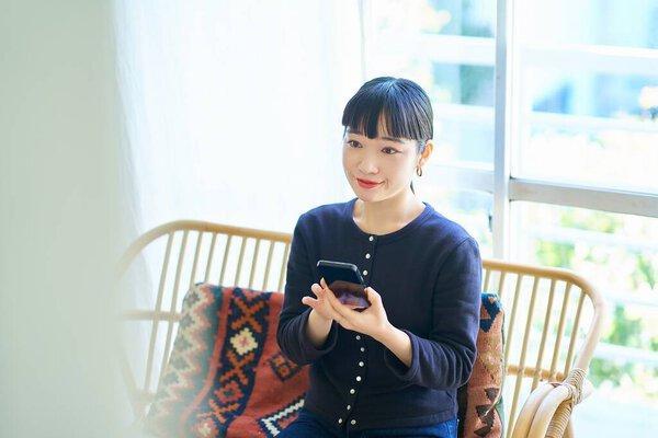 Young woman operating a smartphone in the room