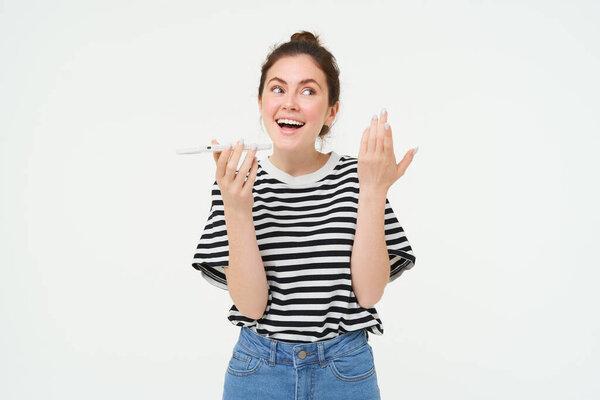 照片中，一个健谈的、快乐的年轻女子在讲手机，记录语音信息，通过电话解释某事，白色背景.