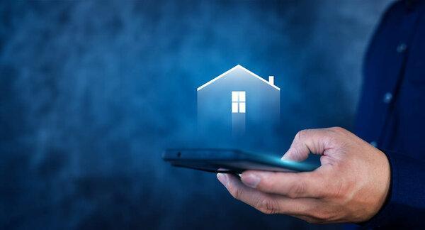 A person is holding a cell phone with a house on the screen. The house is lit up and he is glowing.