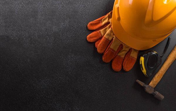 Happy Labor day concept. American flag with different construction tools on dark background.